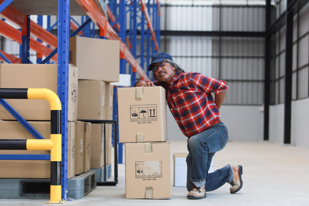 Asian worker man hurt his back 
lift heavy box in factory