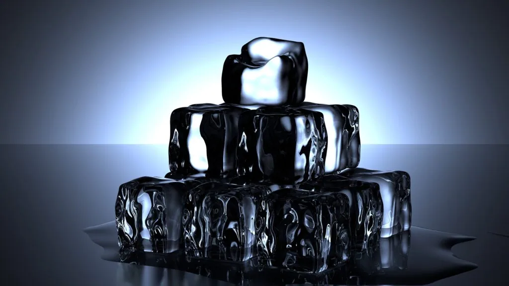 Stacked ice cubes with glossy reflections against a blue-lit background