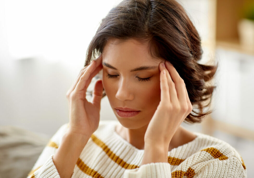 people , health and stress concept - unhappy woman suffering from head ache at home