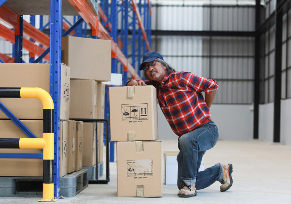 Asian worker man hurt his back 
lift heavy box in factory