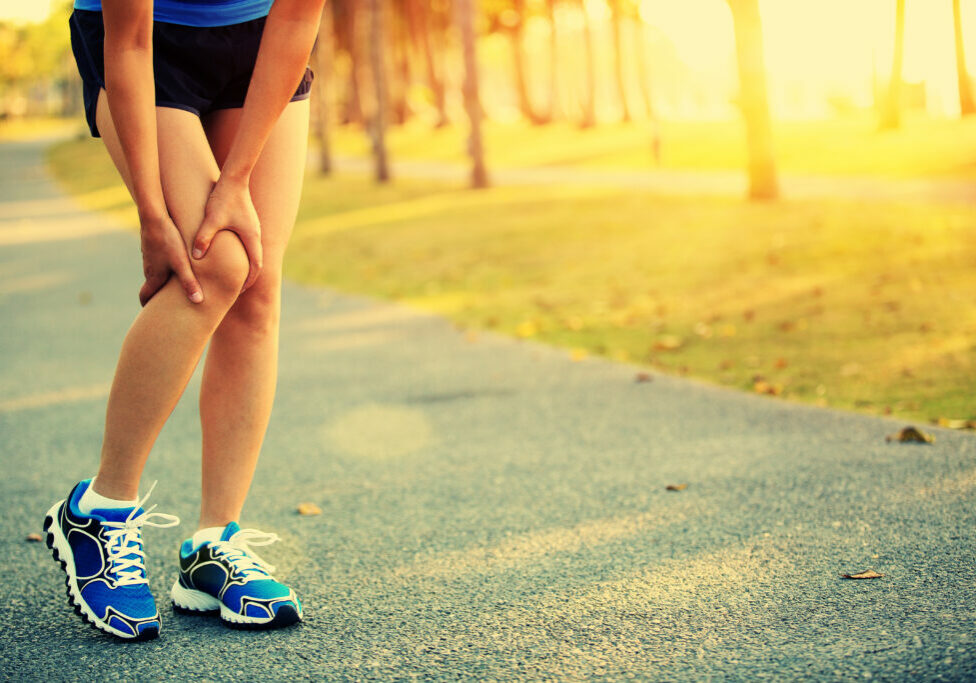 woman runner hold her sports injured knee