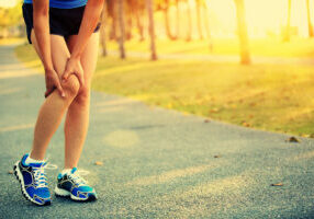 woman runner hold her sports injured knee